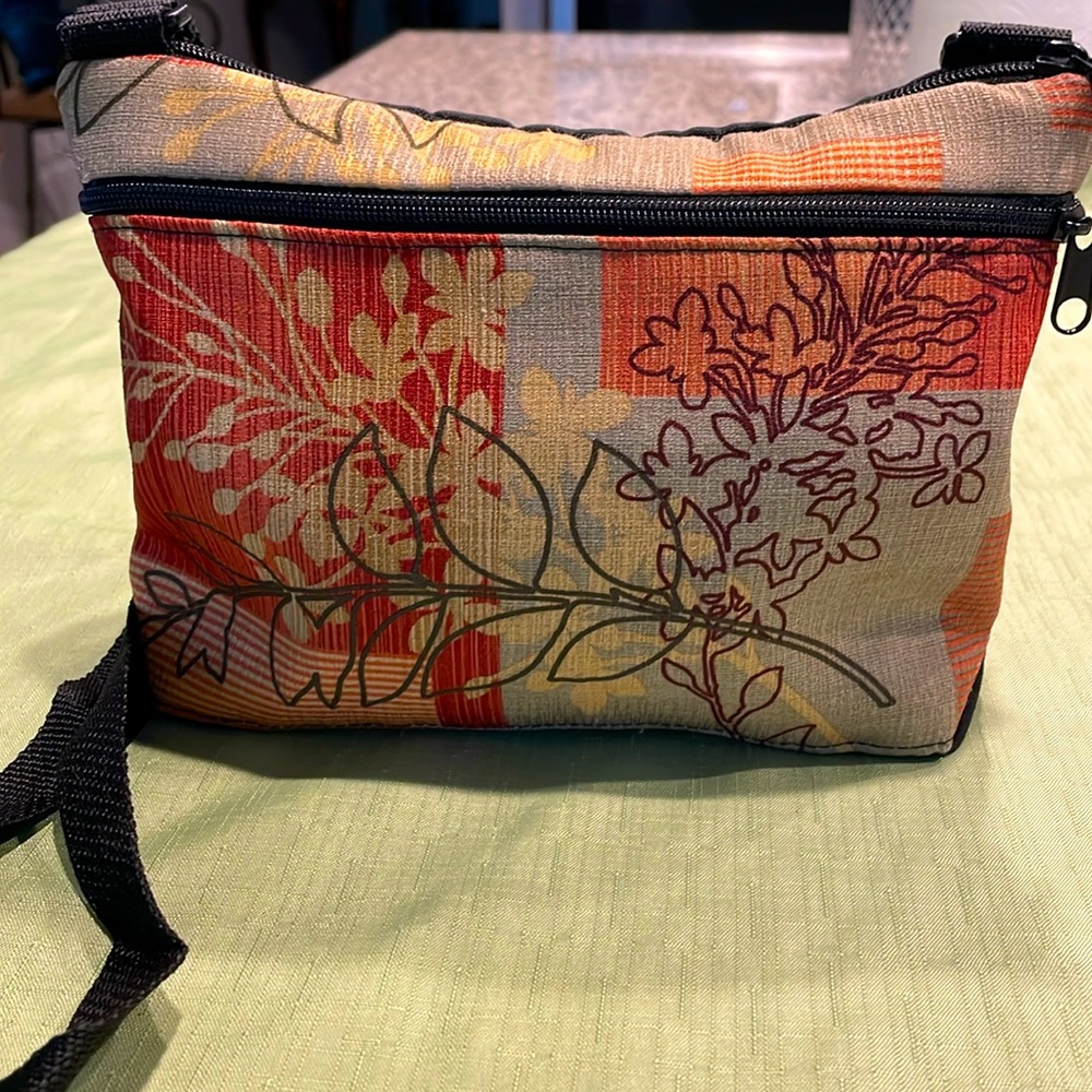 Colorful fabric crossbody bag with adjustable strap. Three sections. Inside pkts